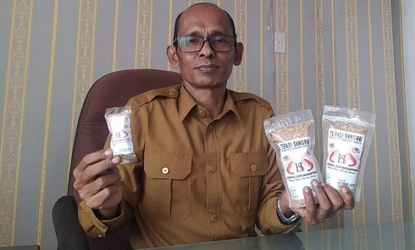 Kepala Dinas Perdagangan, UKM dan Koperasi Aceh Timur, M Khairurradi, memperlihatkan varian terasi hasil produk UMKM HS Terasi Aceh asal Kuala Parek, Kec. Sungai Raya, Aceh Timur, Kamis (5/10). Waspada/Muhammad Ishak