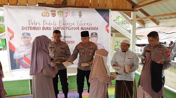 Kapolsek Indra Makmu Ipda Muhammad Alfata, menyerahkan kitab ke santri pedalaman di Dayah Bustanul Hidayah Gampong Alue Ie Mirah, Indra Makmu, Aceh Timur, Jumat (6/10). Waspada/Muhammad Ishak