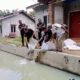 Ketua Edi Saputra didamping Sekretaris Darmawan dan Penasihat Zainal Abidin menabur bibit nila di kolam masyarakat Desa Ujung Negeri Hulu. Waspada/ist