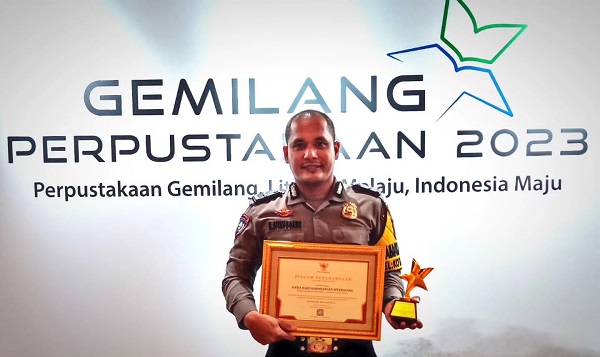 Aipda Hadi Hamonangan Sitanggang memegang piagam penghargaan Nugraha Jasa Dharma Pustaloka Tahun 2023 dari Perpustakaan Nasional RI. Waspada/ist