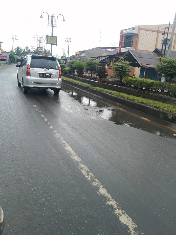 Salah satu lubang jalan nasional yang digenangi air hujan terlihat dalam gambar. Waspada/Seh Muhammad Amin