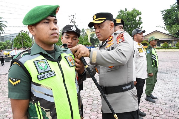 Kapolres Aceh Timur AKBP Andy Rahmansyah SIK, menyematkan pita ditandai dimulainya Operasi Mantap Brata Seulawah 2023 di Lapangan Apel Sarja Arya Racana Polres Aceh Timur di Peudawa, Selasa (17/10). Waspada/H. Muhammad Ishak