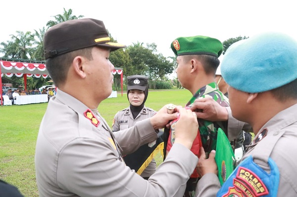 Kapolres Simalungun menyematkan tanda peserta saat apel gelar pasukan Ops Mantab Brata 2023 - 2024.(Waspada/ist).