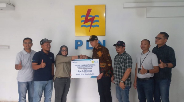 Nabil Arya Barata Lubis, Paskibraka Nasional asal Kab. Mandailingnatal menerima bantuan tabungan pendidikan dari PLN UP3 Padangsidimpuan, didampingi orangtuanya Jeffry Barata Lubis Ketua SMSI Madina. Waspada/ist