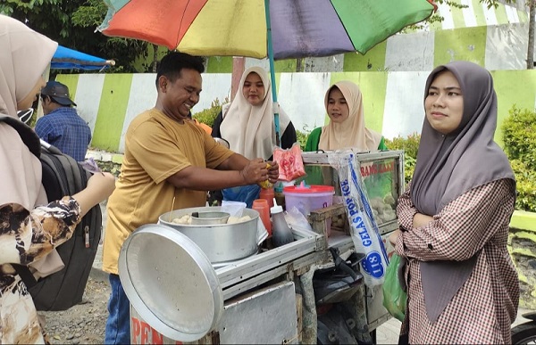 Zaky, pedagang bakso pentol di depan UIN Syahada Padangsidimpuan sedang melayani pembeli./Waspada/Mohot Lubis.