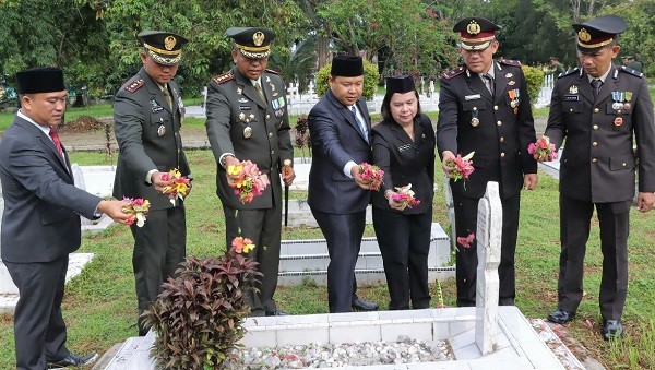 Staf Ahli Bidang Pemerintahan Happy Oikumenis Daely (tiga kanan) mewakili Wali Kota Susanti Dewayani dan Wakapolres Kompol Pardamean Hutahaean (dua kanan) mewakili Kapolres AKBP Yogen Heroes Baruno dan lainnya menabur bunga di salah satu makam saat ziarah nasional memperingati HUT ke-78 TNI di TMP Nagur, Kota Pematangsiantar, Rabu (4/10).(Waspada-Ist).