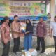 Kepala Diskopukmdag Aceh Besar Trizna Darma ST, menyerahkan secara simbolis paket belanja operasi pasar khusus kepada salah seorang pembeli di Gampong Lamjuhang, Kecamatan Lhoong, Aceh Besar, Kamis (16/11). (Waspada/Ist)