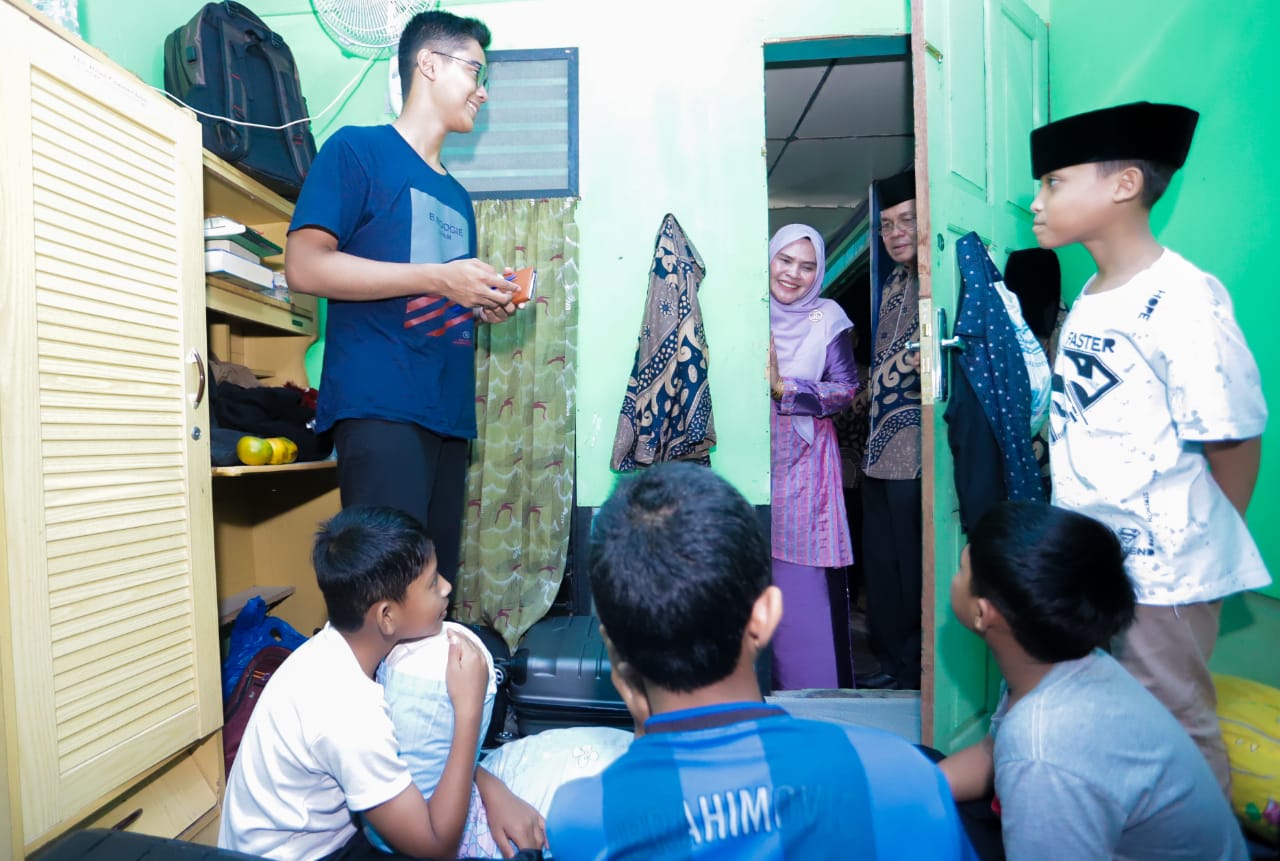 Istri Pj Wali Kota Banda Aceh, Ny. Wardiati, sedang mengintip kegiatan anak-anak Banda Aceh di kamarnya saat mengunjungi pemondokan kafilah Banda Aceh. (Waspada/Ist)