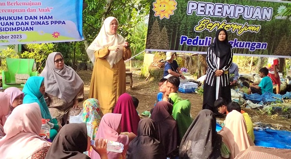 Ketua Tim Pembagian Kepada Masyarakat FKIP UM-Tapsel, Yani Sukriah, MSi memberikan penjelasan kepada masyarakat Desa Purwodadi, Padangsidimpuan, tentang pembutan saos pepaya. Waspada/ist.