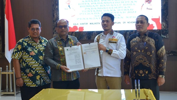 Pj. Wali Kota Padangsidimpuan Dr. Letnan Dalimunthe, M.Kes (2 kiri) dan Ketua Bawaslu Padangsidimpuan Ratno Afandi, menunjukkan NPHD anggaran Pilkada Tahun 2023 untuk Bawaslu Padangsidimpuan yang telah ditandatangani, Kamis (9/11/).Waspada/ist.