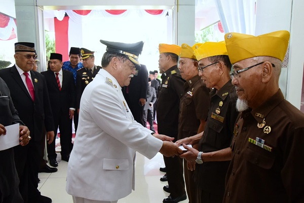 Plt Bupati Deliserdang HM Ali Yusuf Siregar menyerahkan tali asih kepada salah seorang Veteran usai menjadi Irup pada Hari Pahlawan Tahun 2023 di loby depan Kantor Bupati Deliserdang, Jum’at (10/11).- (Waspada/Khairul K Siregar/B)