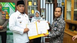 Bupati Madina HM Jafar Sukhairi Nasution didampingi Wabup Madina Atika Azmi Utammi Nasution menandatangani kesepakatan NPHD, Jumat (24/11), untuk Pilkada serentak 2024 dengan total anggaran Rp81,5 miliar. Waspada/Ist