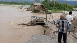 Oprit jembatan rangka baja Pantei Dona Aceh Tenggara, telah menjadi alirang sungai akibat digerus Sungai Alas, Kamis (23/11) malam. Waspada/Ist