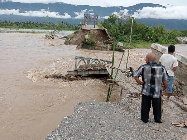 Oprit jembatan rangka baja Pantei Dona Aceh Tenggara, telah menjadi alirang sungai akibat digerus Sungai Alas, Kamis (23/11) malam. Waspada/Ist