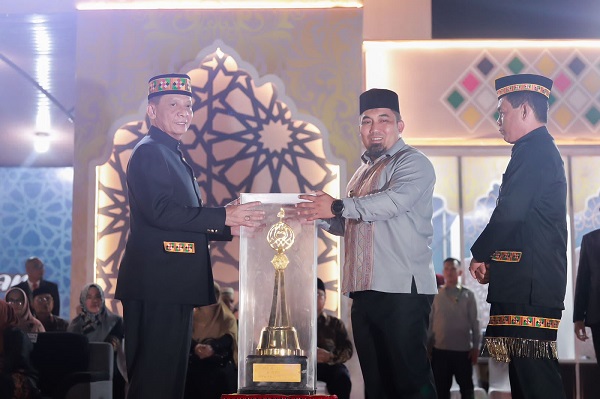 Pj Bupati Aceh Besar Muhammad Iswanto menyerahkan Piala Bergilir kepada Pj Gubernur Aceh Achmad Marzuki pada saat Pembukaan MTQ Ke-36, yang berlangsung di Lapangan Alun-Alun Pendopo Bupati Simeulue, Minggu (26/11) malam. (Waspada/Ist)