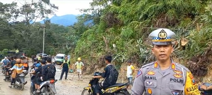 Kasat Lantas Polres Taput, AKP Dahnial Saragih bersama personel lalu lintas sedang mengatur arus lalu lintas di lokasi jalan longsor. Waspada/ist