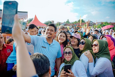 WALI Kota Medan Bobby Nasution dan Ketua TP PKK Kota Medan Ny Kahiyang Ayu berfoto bersama ratusan warga usai Senam Kolaborasi Lembaga Kemasyarakatan Kecamatan Medan Selayang di Lapangan Jalan Ringroad Lingkungan XIII, Kelurahan Tanjung Sari Kecamatan Medan Selayang, Kamis (23/11) sore. Waspada/Ist