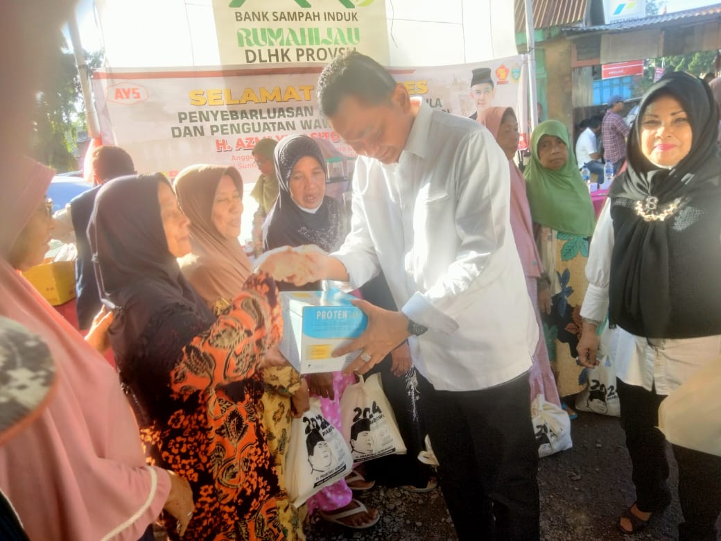 ANGGOTA DPRD Sumut H Azmi Yuli Sitorus, SH, M.SP (AYS, kanan) menyerahkan bantuan berupa susu protein kepada para warga lanjut usia (lansia). Waspada/Ist