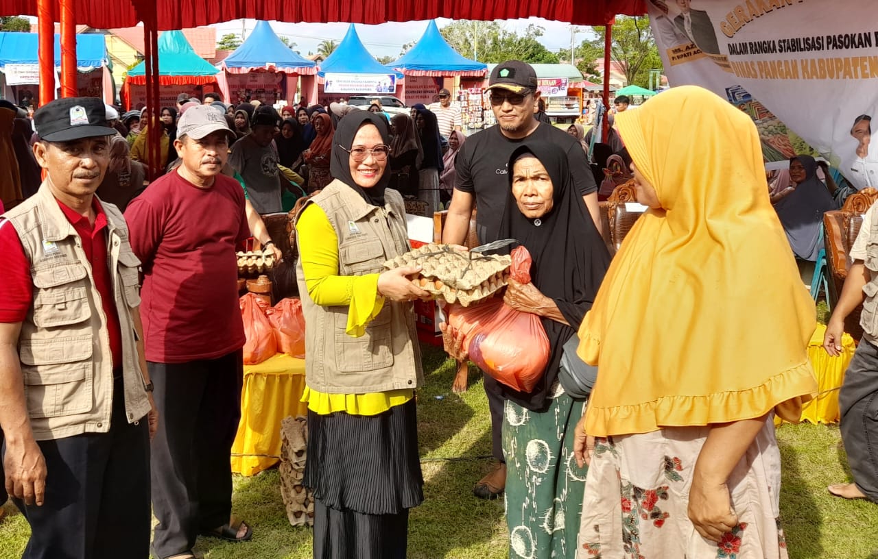 Ketua TP PKK Ny Emma Malini Azmi bersama Kadis Pangan Kabag Perekonomian Rully Suhaidi, Camat Singkil Khairuddin saat menyerahkan simbolis bahan pangan murah kepada masyarakat, pada penjualan hari pertama pembukaan Expo UMKM. WASPADA/Ariefh