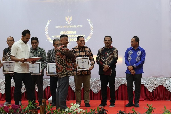 Pj Bupati Abdya Darmansah, didampingi Kepala Dinas Komunikasi Informasi dan Persandian Ubai Rizal ST, menerima penghargaan keterbukaan informasi publik di Banda Aceh. Rabu (6/12).Waspada/Ist