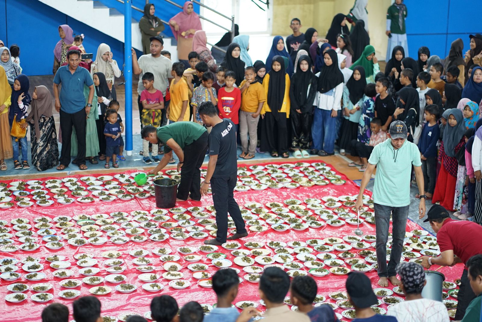 Masyarakat Kota Jantho dan para PNS Pemkab Aceh Besar makan khanduri bersama di gedung utama Jantho Sport City (JSC), Minggu (24/12) sore. (Waspada/Ist)