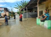 BEBERAPA warga memperlihatkan kondisi banjir di Dusun I Gg. Bilal Desa Bakaran Batu Kecamatan Batangkuis akibat tanggul sungai jebol, Selasa (26/12). (Waspada/Khairul K Siregar/B)