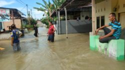 BEBERAPA warga memperlihatkan kondisi banjir di Dusun I Gg. Bilal Desa Bakaran Batu Kecamatan Batangkuis akibat tanggul sungai jebol, Selasa (26/12). (Waspada/Khairul K Siregar/B)