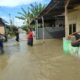 BEBERAPA warga memperlihatkan kondisi banjir di Dusun I Gg. Bilal Desa Bakaran Batu Kecamatan Batangkuis akibat tanggul sungai jebol, Selasa (26/12). (Waspada/Khairul K Siregar/B)