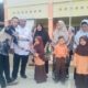 Maulizar Zikri,anggota DPRK Aceh Tamiang saat menyerahkan bantuan pakaian seragam sekolah untuk murid SDN 2 Tualang Cut,Kec Manyak Payed,Jumat (1/12).(Waspada/Yusri)