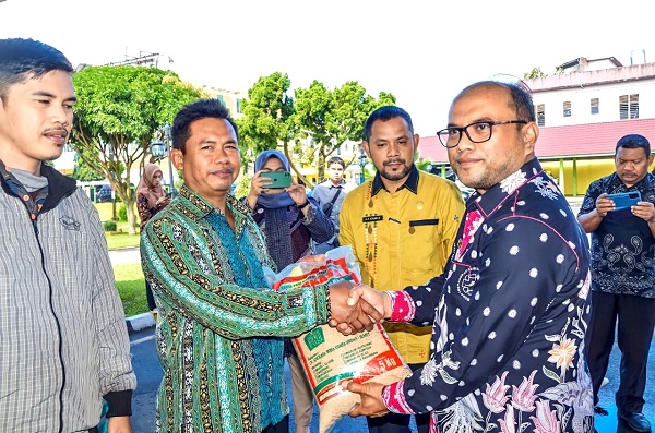 Pj.Wali Kota Padangsidimpuan, Dr. Letnan Dalimunthe (kanan) menyerahkan bibit padi kepada salah seorang petani di Pendopo Kantor Walikota, Jl.Sudirman, Padangsidimpuan, Kamis (7/12). Waspada/ist.