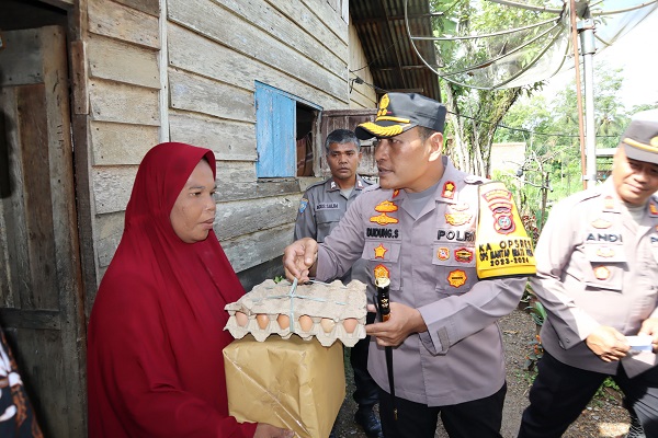 Kapolres Padangsidimpuan AKBP Dudung Setyawan pada program Jum'at Berkah serahkan bantuan kepada warga Desa Aek Bayur. (Waspada/Ist)