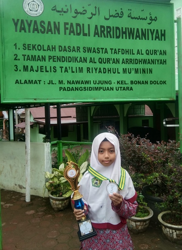 Maher Al Hakim, siswa SD Swasta Tafdhil Al Qur’an, Bonan Dolok, Padangsidimpuan menunjukkan piala dan medali Juara I Lomba Puisi Creatifa Indonesia Tingkat Nasional Tahun 2023.Waspada/ist