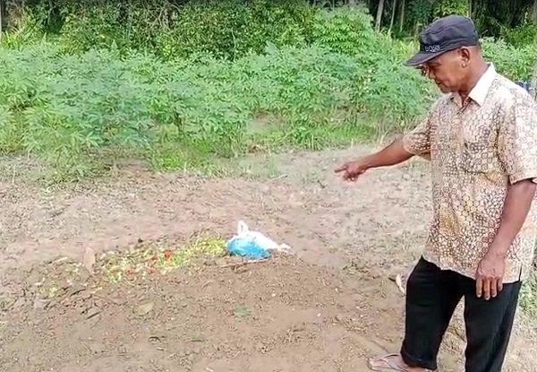 Salah satu kerabat korban memperlihatkan kuburan Ngatmini, yang meninggal karena dianiaya anak kandung, di Desa Sei Kamah, Kec Seidadap, Kab Asahan. Waspada/Sapriadi