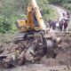 Warga Desa Lumban Silintong, Kecamatan Pagaran dibantu alat berat gotong-royong membangun jembatan darurat dari pohon aren dan kayu pinus di Jalan Tambokan, Rabu (13/12). Waspada/Hotbin Purba