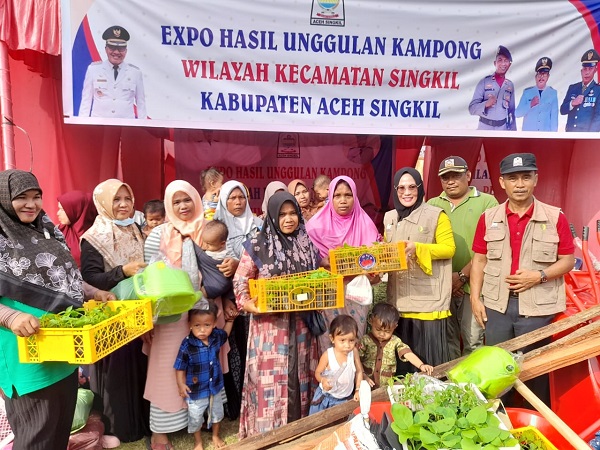 Ketua TP PKK Ny Emma Malini Azmi didampingi Kadis Pangan saat menyerahkan bantuan benih dan peralatan pertanian kepada 12 KK di Kecamatan Singkil, Minggu (17/12). WASPADA/Ariefh