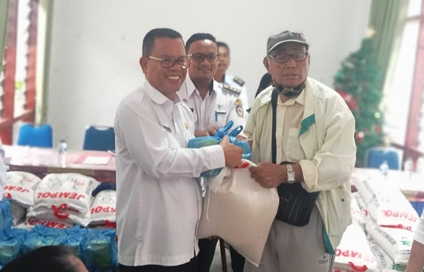 BUPATI Toba, Poltak Sitorus (kiri) saat memberikan bantuan beras kepada salah satu Lansia. Waspada/Ist