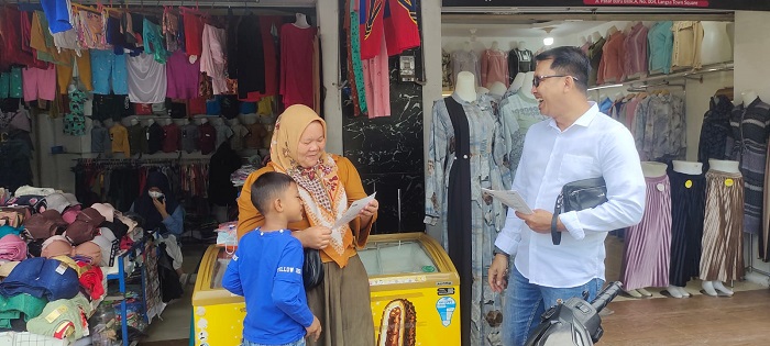 Kepala BPJS Ketenagakerjaan atau BPJamsostek Cabang Langsa, Muhammad Kurniawan saat menyapa pedagang melakukan sosialisasi manfaat program BPJamsostek kepada para pedagang di Pajak Peukan Langsa di Gampong Peukan Langsa, Kecamatan Langsa Kota, Kamis (21/12). Waspada/dede