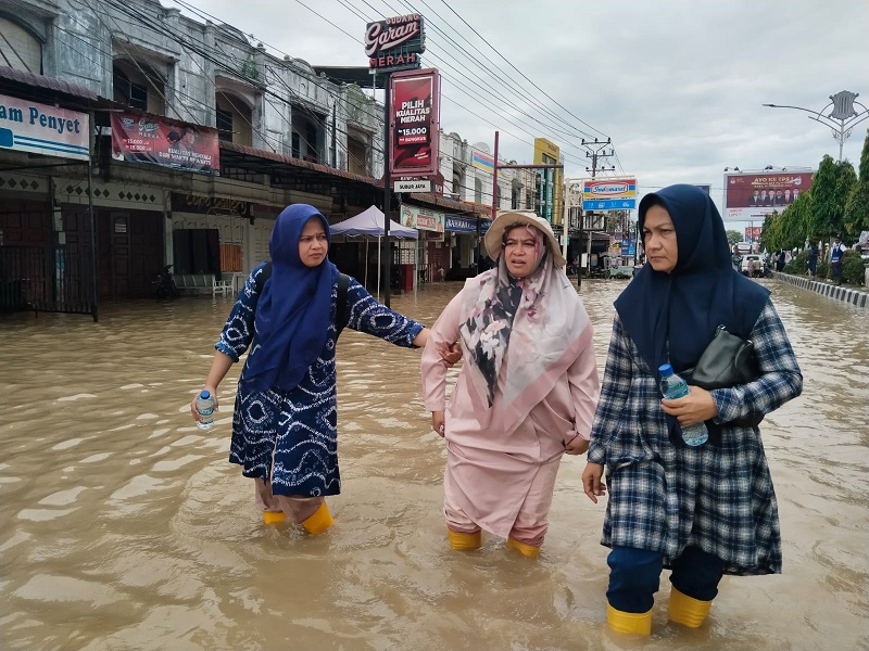 Isteri Pj Bupati Aceh Utara memgarungi banjir di Lhoksukon kemarin. Waspada/Ist