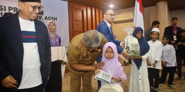 Sekda Aceh, Bustami Hamzah, saat menyerahkan beasiswa kepada anak yatim pada kegiatan implementasi program beasiswa yatim tahap IV Provinsi Aceh bekerjasama RQV dengan Hayrat Yardim Indonesia di Aula Serbaguna Setda Aceh, Banda Aceh, Senin (4/12). (Waspada/Zafrullah)