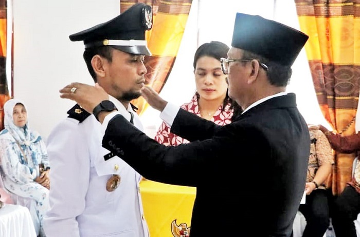 Wabup H.Zonny Waldi menyematkan tanda jabatan kepada Dedi Wahyudi sebagai Pangulu Nagori Bandar Malela, Kamis (11/1).(Waspada/ist).