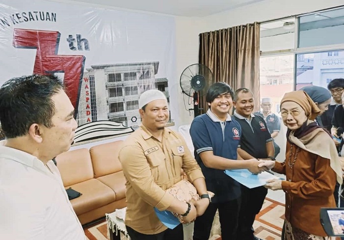 Pemimpin Umum Harian Waspada dr. Hj. Rayati Safrin, MM, MBA, saat menyerahkan piagam penghargaan kepada Edward Limbong.(Waspada/ist).