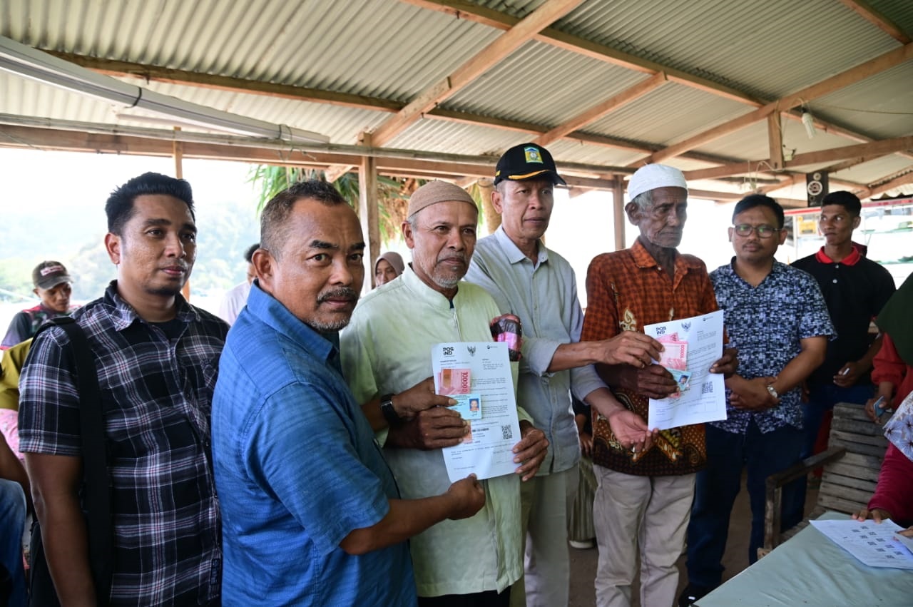 Asisten II Aceh Besar Bidang Perekonomian dan Pembangunan M.Ali S.Sos, M.Si menyerahkan dana bantuan sosial Program Keluarga Harapan (PKH) dan bantuan sembako kepada warga Pulo Breuh, di Gampong Gugop Kecamatan Pulo Aceh, Aceh Besar, Minggu (18/2). (Waspada/Ist)