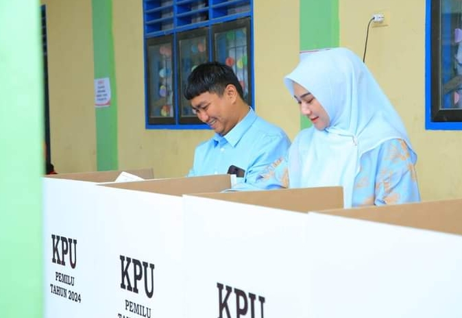 Bupati Labura Hendriyanto Sitorus bersama isteri dr.Rama Dhona Sihotang saat melakukan pencoblosan di TPS.03 Aek Kanopan, Kualuhhulu, Rabu (14/2). Waspada/ist