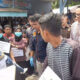 Tersangka IR saat melakukan reka adegan, hendak membawa korban anak tirinya yang diketahui sudah tidak bernafas ke Puskesmas, dengan menumpang warga yang lewat. WASPADA/Ariefh.