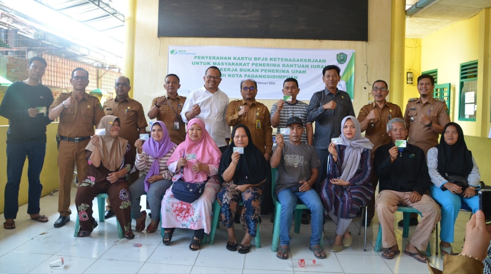 Kepala BPJamsostek Cabang Padangsidimpuan Eris Aprianto (5 kiri belakang) , Pj.Wali Kota Padangsidimpuan Dr. H. Letnan Dalimunthe, M.Kes (5 kanan) dan Ketua DPRD Padangsidimpuan Siwan Siswanto (3 kanan) foto bersama dengan pekerja bukan penerima upah yang telah menerima Kartu BPJS Ketenagakerjaan, di Aula Kantor Camat Padangsidimpuan Selatan, Rabu (28/2). Waspada/ist.