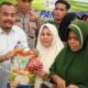 Asisten II Pemkab Aceh Besar, M. Ali menyerahkan sembako murah secara simbolis saat gelar pangan murah untuk masyarakat di Halaman Meunasah Gampong Layeun, Kecamatan Leupung, Aceh Besar, Rabu (28/2). (Waspada/Ist)