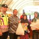 Asisten II Sekdakab Aceh Besar M. Ali didampingi Pegawai Dinas Pangan Aceh Besar dan Anggota Polsek Darul Imarah menyerahkan paket pangan murah Pemkab Aceh Besar secara simbolis kepada salah seorang pembeli di Gampong Lheu Blang, Kecamatan Darul Imarah, Aceh Besar, Kamis (29/2). (Waspada/Ist)
