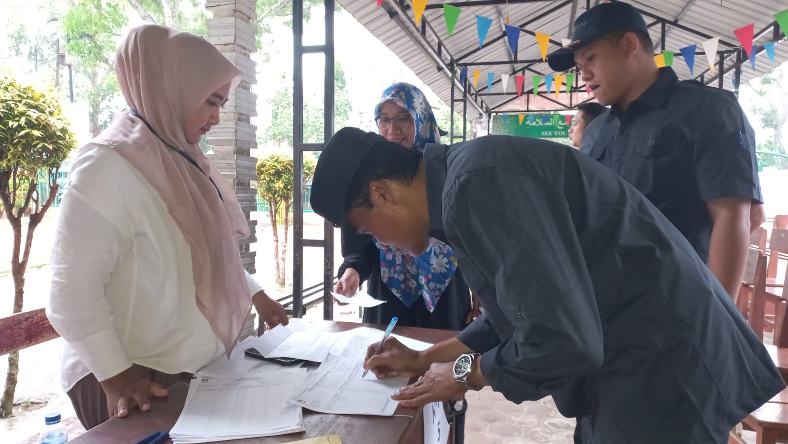 Diguyur Hujan, Pj Wali Kota Langsa Nyoblos Di TPS 22 Diguyur Hujan, Pj Wali Kota Langsa Nyoblos Di TPS 22