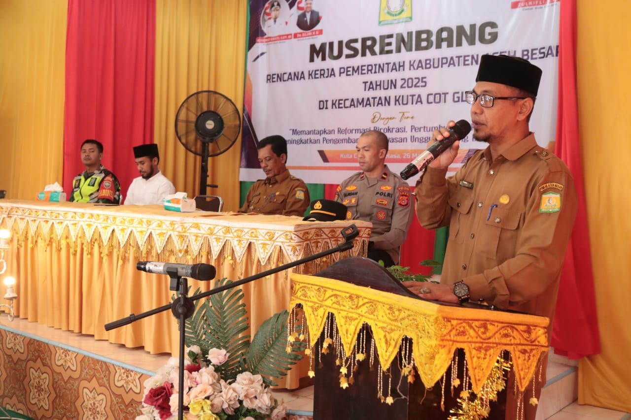 Camat Kuta Cot Glie Zulkifli SSos memberikan laporan pelaksanaan Musrenbang Tahun 2025 di Aula UDKP Kecamatan Kuta Cot Glie, Selasa (26/3). (Waspada/Ist)