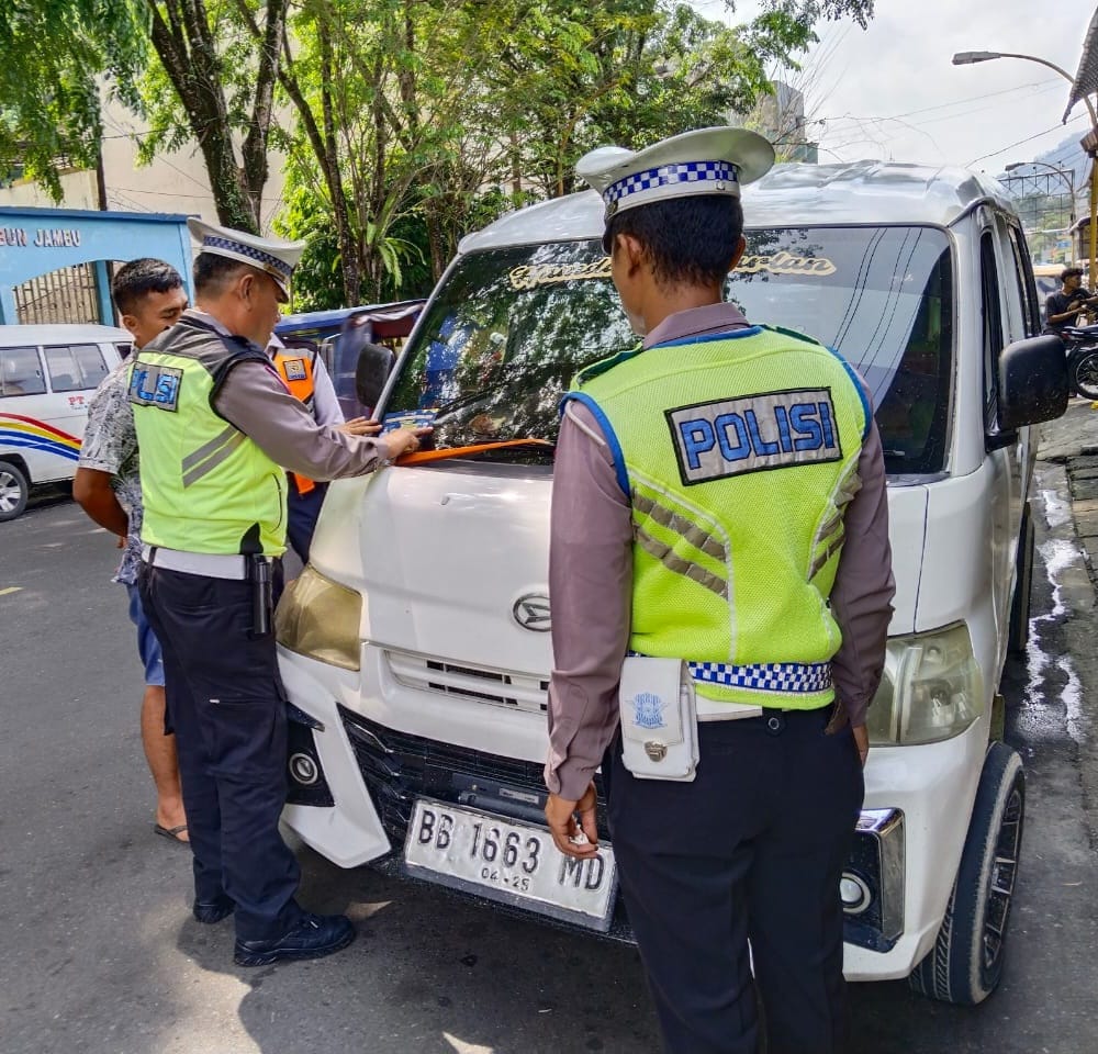 Satuan Lalu Lintas Polres Sibolga tempel stiker imbauan tertib berlalu lintas di kendaraaan umum dalam rangka Operasi Keselamatan Toba 2024 di wilayah Hukum Polres Sibolga, Selasa (19/3). Waspada/ist